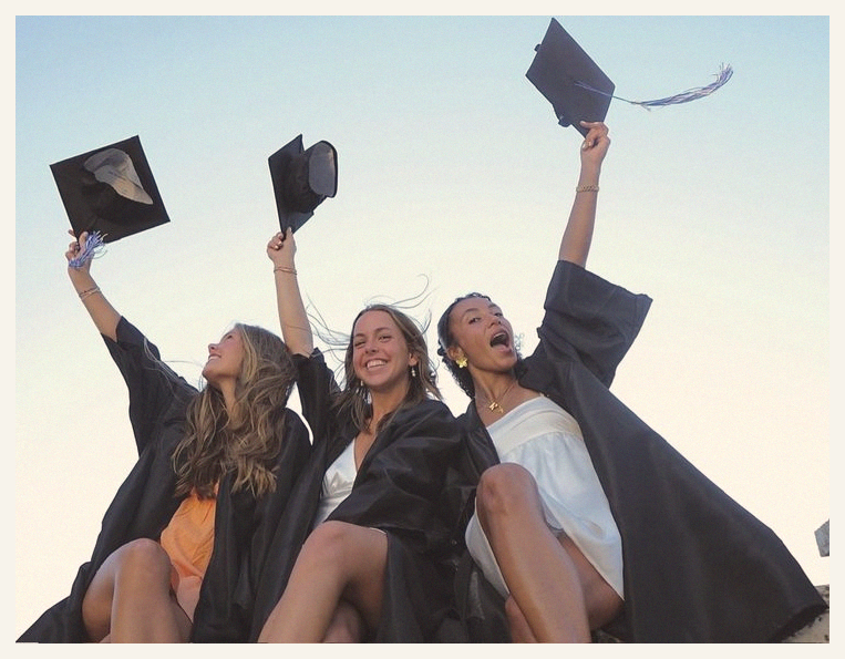 Vintage film print of three graduates tossing their caps